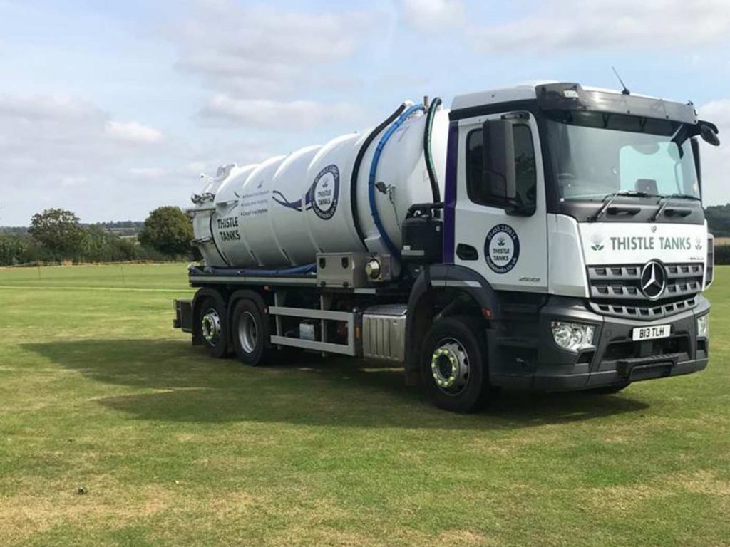 Thistle tanks lorry on grass, ready to carry out septic tank emptying