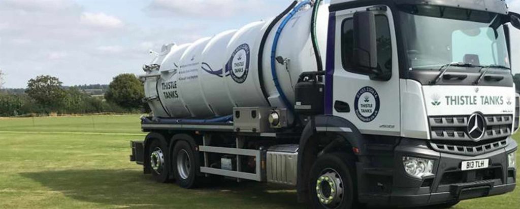 Thistle Tanks vacuum truck driving on grass to empty cess pit